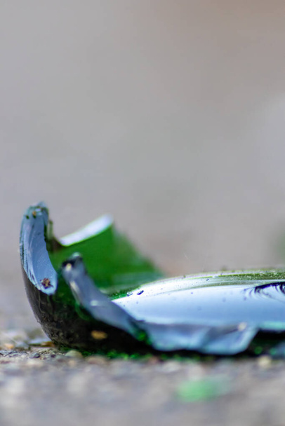 Los fragmentos afilados de una botella de vidrio rota en el suelo con cuchillas afiladas son peligrosos por el vandalismo y las personas borrachas que muestran frágiles botellas y bebidas trituradas como residuos de reciclaje de armas - Foto, imagen