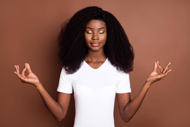Portrait of attractive calm focused girl meditating mental health isolated over brown color background - Φωτογραφία, εικόνα