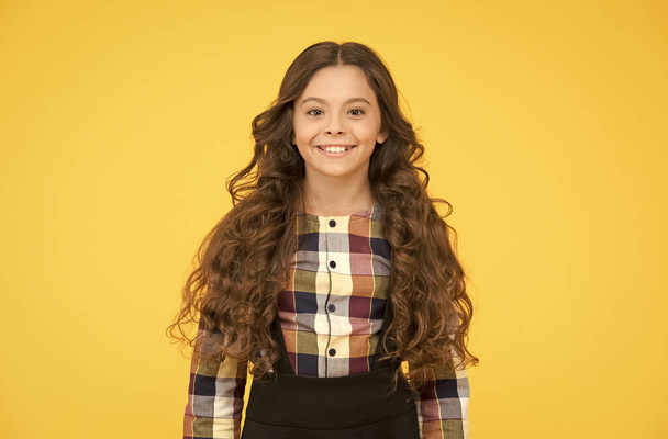I feel beautiful today. Beauty look of little schoolchild. Happy girl with school look. Small kid wear uniform yellow background. Vogue look. Back to school fashion. Hair salon. Born to be real - Photo, Image