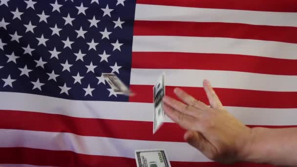 Zuhanó dollár a háttérben az amerikai zászló.Lassított felvételen. Pénzeső. - Felvétel, videó