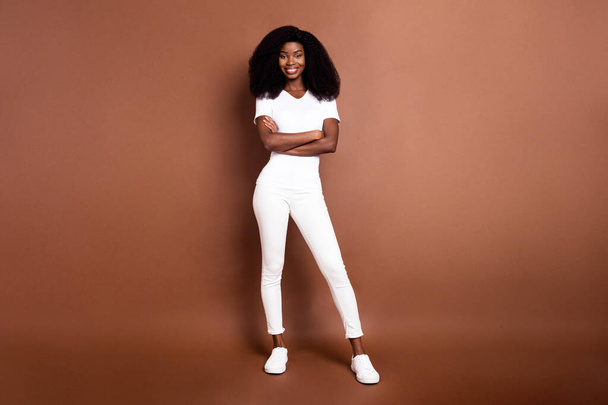 Full length photo of young black girl happy positive smile confident folded hands isolated over brown color background - Φωτογραφία, εικόνα