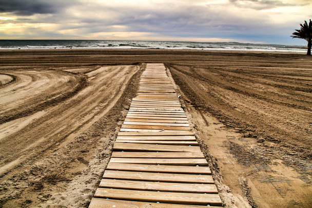 Pasarela de madera a la playa por la mañana en un día nublado - Foto, Imagen