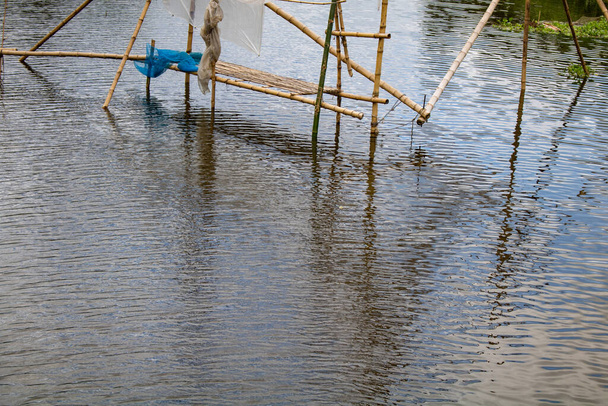 Redes de pesca de bambú. Una hermosa vista del río de Bangladesh. Pescadores pescan en el río para conseguir redes. - Foto, imagen