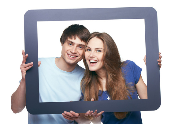 Happy couple looking through tablet frame - 写真・画像