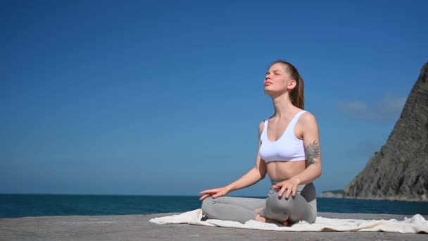 Práctica de yoga y meditación al aire libre. Chica en el muelle en el fondo del mar - Metraje, vídeo