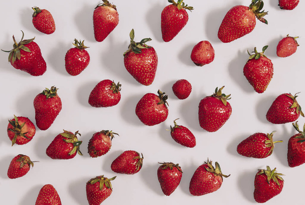 Les fraises rouges mûres s'étendent sur fond blanc. Modèle plat de pose, concept rafraîchissant d'été - Photo, image