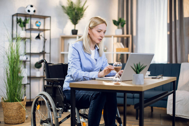 Handicapped woman using laptop for remote work - 写真・画像