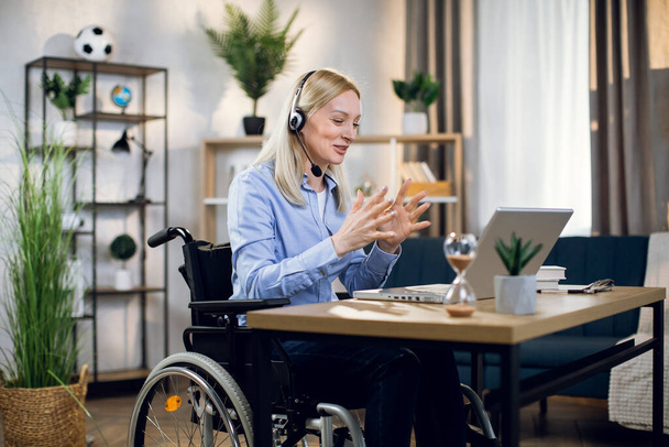 Handicapped woman using headset and laptop for video call - Фото, зображення