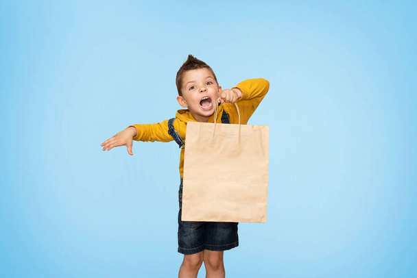 Little cute kid boy holding craft package isolated on background. - Foto, Imagen