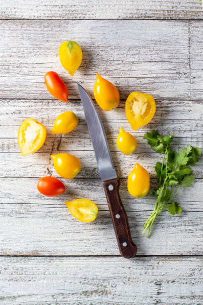 various colorful ripe tomato on white wooden background. Cooking from yellow orange and red cherry tomatoes. Top view with copyspace - Φωτογραφία, εικόνα