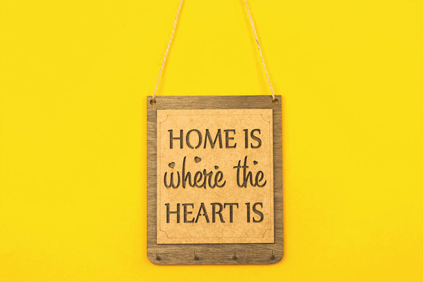 Wooden plate Home is where the heart is, cozy home decoration concept  - Fotó, kép