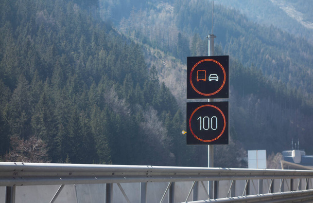 道路上の時速100キロの速度制限交通標識 - 写真・画像