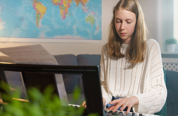 Teenage dívka hraje elektronické hudební nástroj doma. - Fotografie, Obrázek