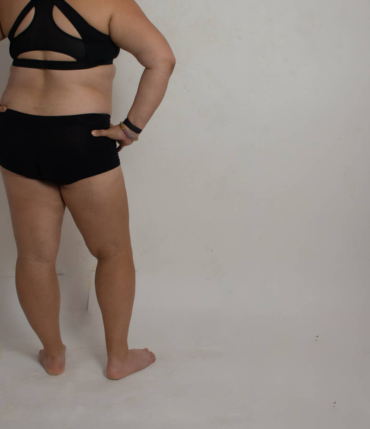 Chubby white woman showing her self love and belief in postive body on a white background - Foto, Imagen