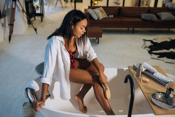 Молодая женщина чистит кожу. Здоровая женщина в ванной. - Фото, изображение