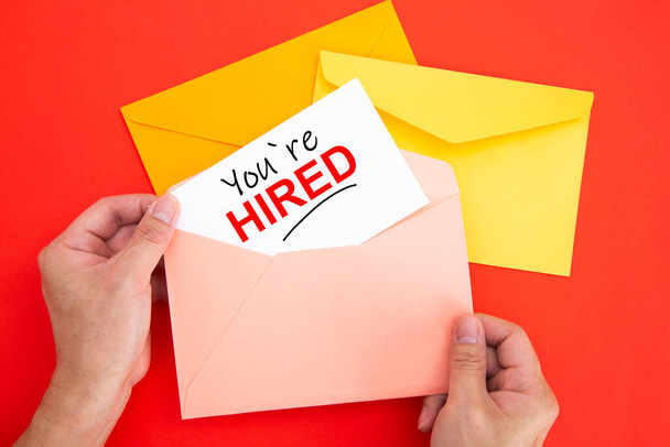 You're Hired Concepts - Hand holding a envelope and white post card - Photo, Image