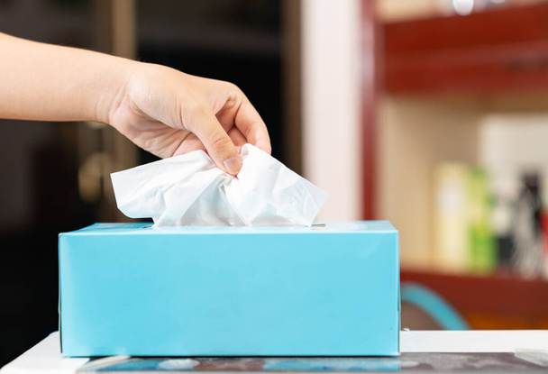 L'homme cueillant à la main du papier de soie blanc dans une boîte en tissu bleue.Concept de soins de santé. - Photo, image