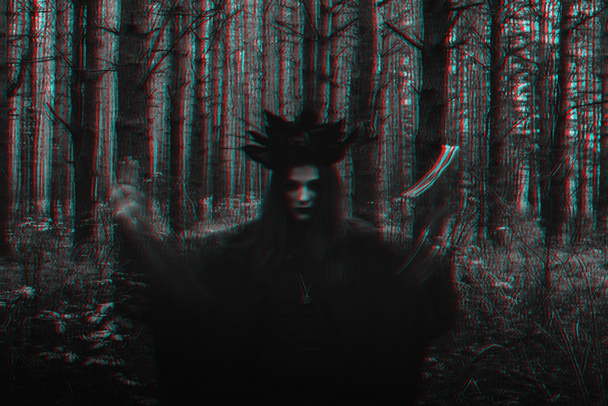 čarodějnice v černém kostýmu provádí tmavá kouzla se svíčkami v lese - Fotografie, Obrázek