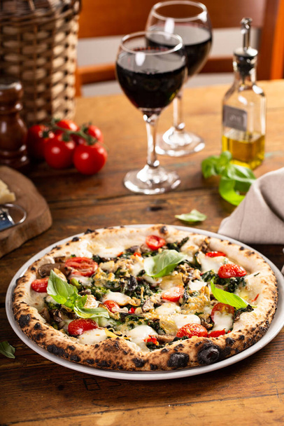 Freshly baked vegetarian Neapolitan pizza with mushrooms and artichokes - Foto, afbeelding