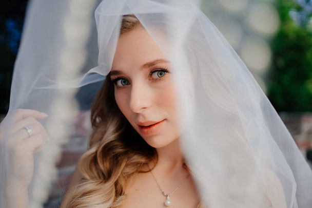 beautiful bride with long wavy hair under the veil. Wedding make-up.  - Foto, immagini