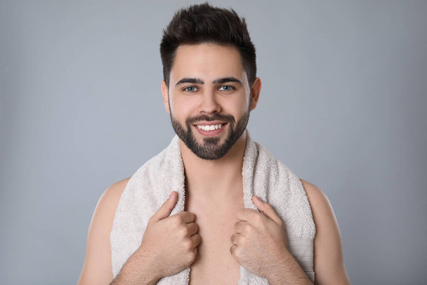 Handsome young man with beard after shaving on grey background - Foto, Imagem