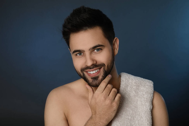 Handsome young man with beard after shaving on blue background - Fotoğraf, Görsel