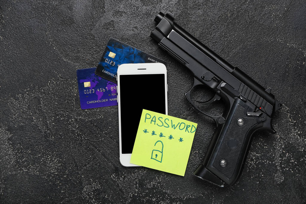 Kännykkä, ase, luottokortit ja paperi tekstillä PASSWORD tummalla taustalla. Petosten käsite - Valokuva, kuva