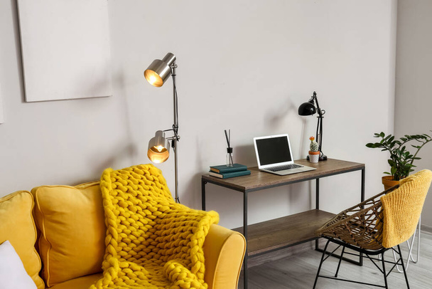 Интерьер стильной гостиной с светящимися лампами и удобным рабочим местом - Фото, изображение