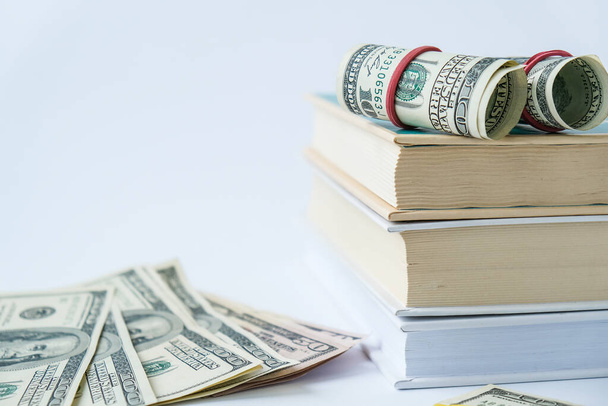 Wissen führt zu Wohlstand. Stapel Bücher mit Dollars. Konzept der teuren Bildung. Geld in Büchern. Sparen für die Uni-Stadt. Ersparnisse, bezahlte Studiengebühren - Foto, Bild