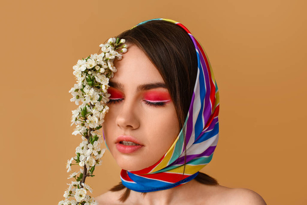 Kaunis nuori nainen kukkivat kevään oksat värillinen tausta - Valokuva, kuva