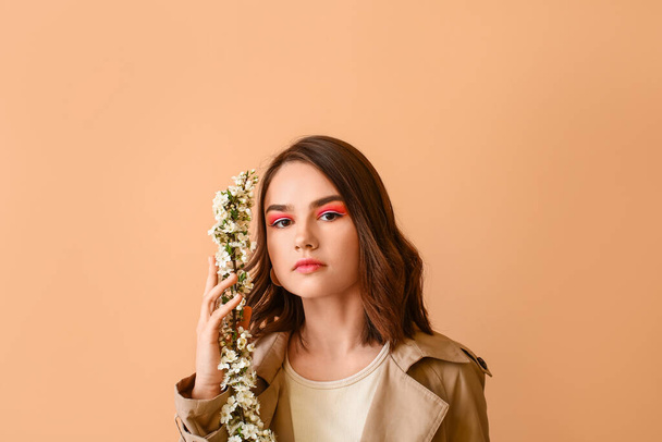 Beautiful young woman with blooming spring branches on color background - Φωτογραφία, εικόνα