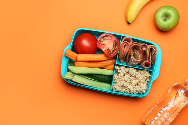 Lunchbox z smacznym jedzeniem na tle koloru - Zdjęcie, obraz
