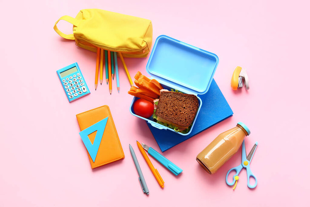Lunch box with tasty food and school stationery on color background - Fotoğraf, Görsel