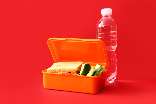 Scatola da pranzo con cibo gustoso su sfondo a colori - Foto, immagini