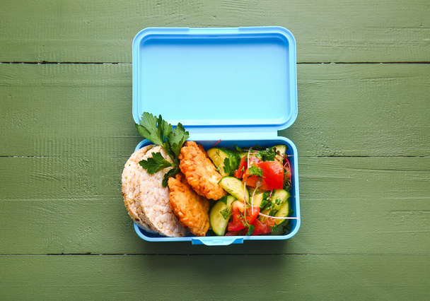 Boîte à lunch avec nourriture savoureuse sur fond en bois - Photo, image