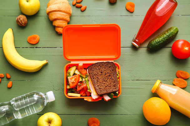 Oběd box s chutným jídlem na dřevěném pozadí - Fotografie, Obrázek