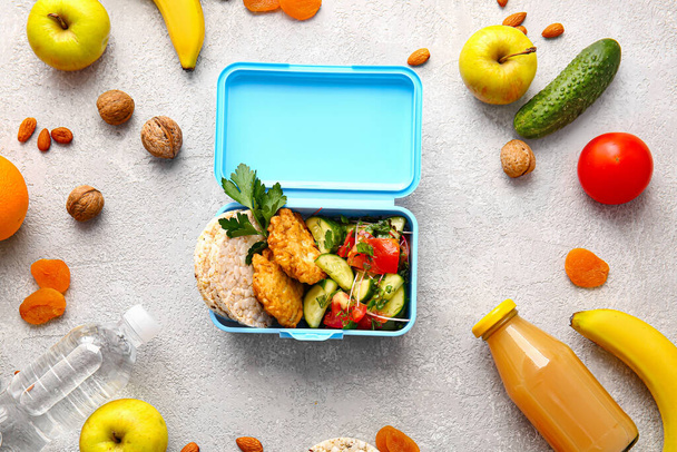 Lunchbox met lekker eten op lichte achtergrond - Foto, afbeelding