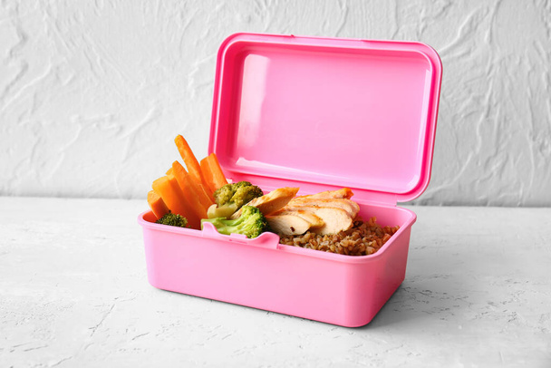 Lunchbox met lekker eten op tafel - Foto, afbeelding