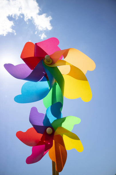 Sesión de fotos de unos molinetes multicolores lanzados al cielo azul  - Foto, Imagen