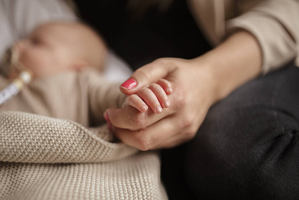 Una mujer sosteniendo la mano de su bebé recién nacido - Foto, Imagen