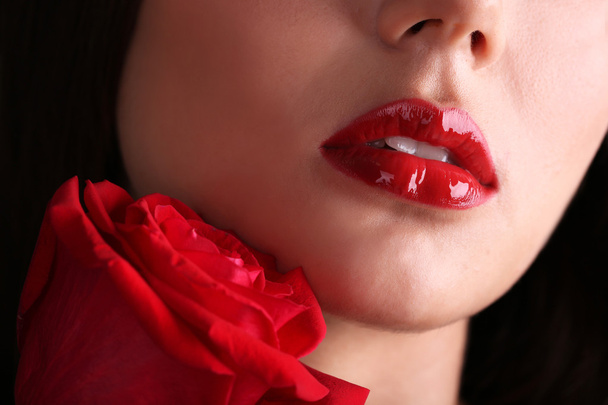 Girl with red lips and rose on dark background - Photo, Image