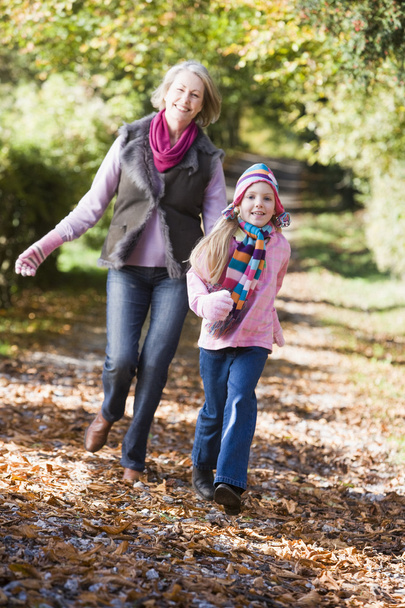Grandmother and granddaughter playing in autumn woods - Photo, image