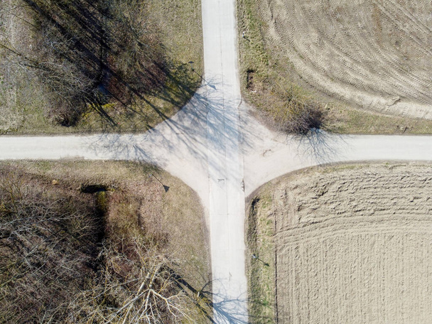 An overhead shot of an intersection in rural area with plains fields and trees - Фото, зображення
