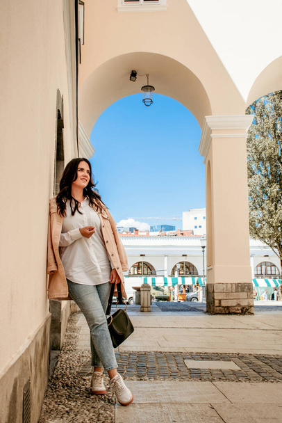 Full length portrait of attractive young woman in casual but stylish spring clothes in city of Ljubljana, Slov - Zdjęcie, obraz