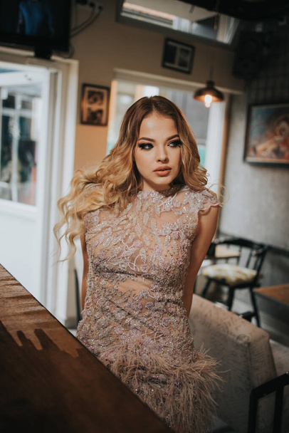 An attractive woman in an evening dress blonde hairs and makeup posing - Valokuva, kuva