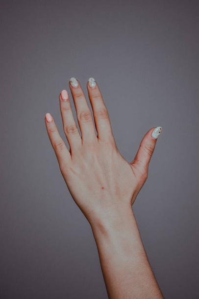 A vertical closeup shot of a female hand with a fresh manicure - Zdjęcie, obraz