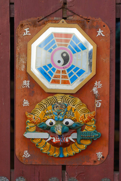 Nahaufnahme des traditionellen chinesischen Yin und Yang Talismans auf roter Oberfläche - Foto, Bild