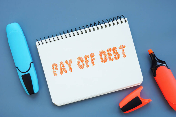 Business concept meaning PAY OFF DEBT with phrase on the piece of paper. - Photo, Image