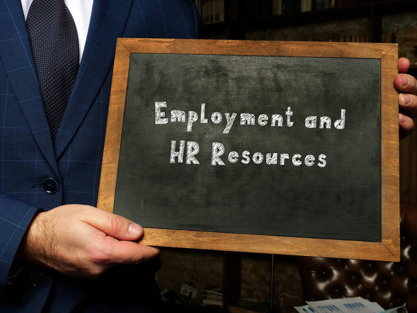 Üzletember egy táblával a kezében. Üzleti koncepció a foglalkoztatásról és a HR-forrásokról a lapon szereplő kifejezéssel - Fotó, kép
