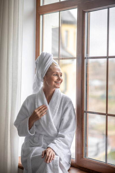 A woman in a white robe relaxing after the bath - Foto, Imagem